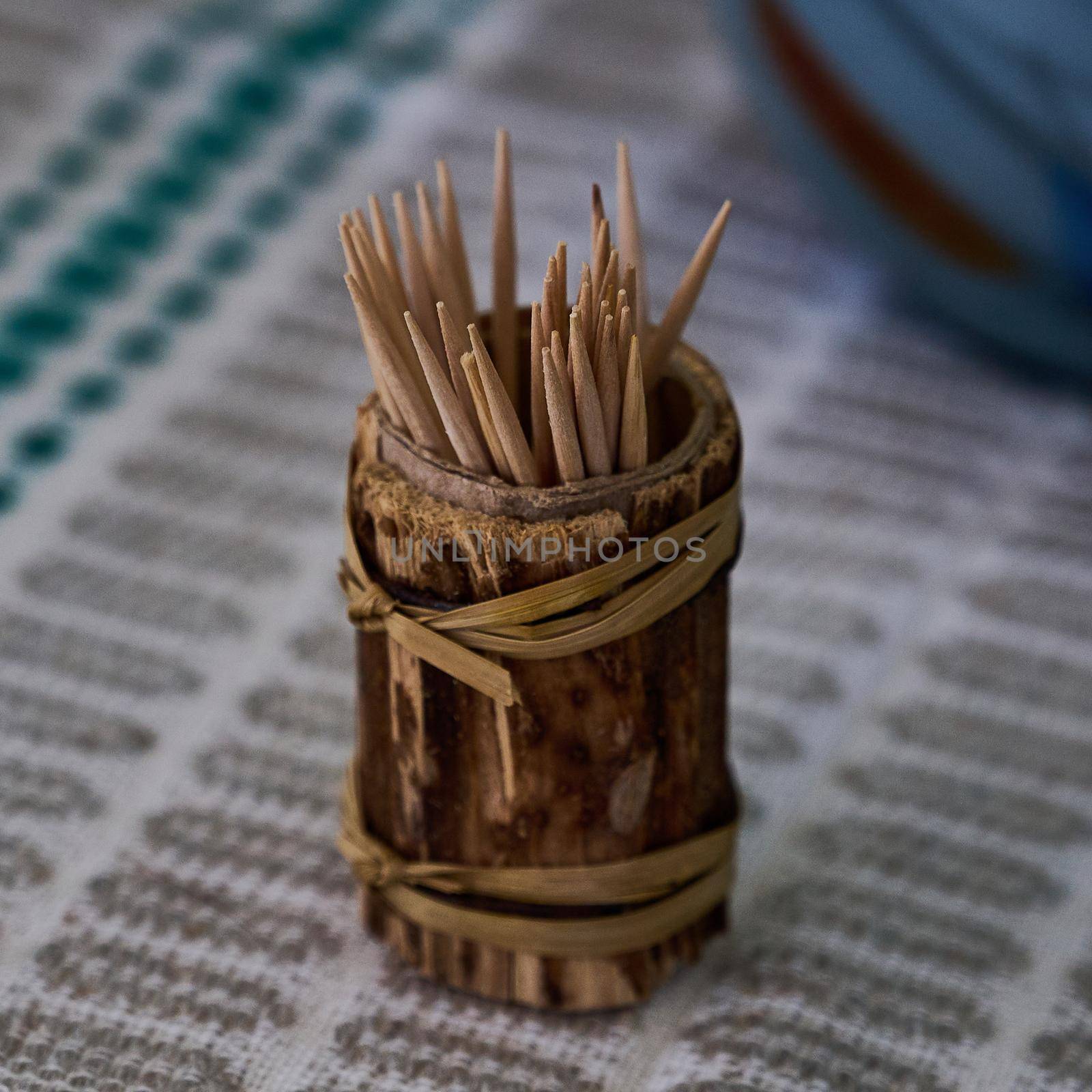 a jar with wooden toothpicks is on the table close-up photo
