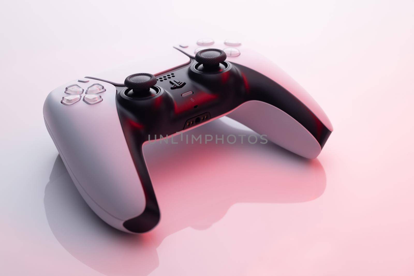 NEW YORK - March 3, 2021: Sony Playstation 5 Dualsense game controller. New product from Sony, wireless white PlayStation 5. White controller in red light. by uflypro