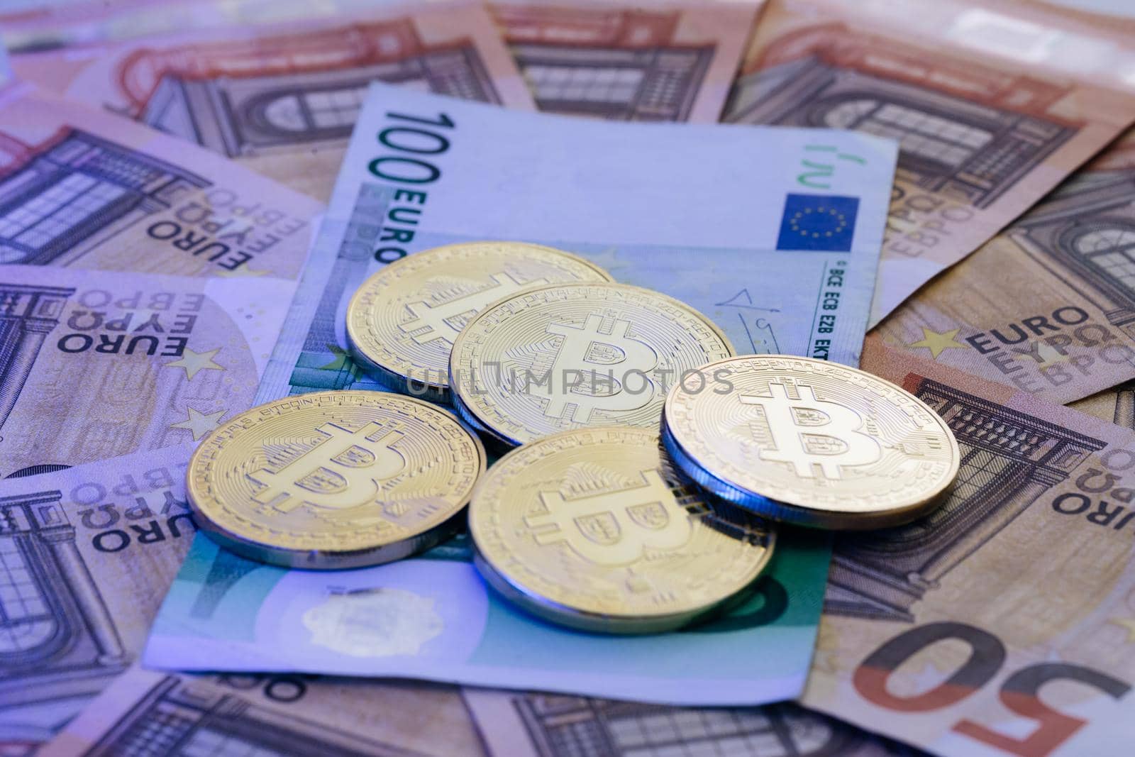 Euro banknotes. Euro bills. Coin with symbol of cryptocurrency of bitcoin lies on real banknotes of European Union, euro, new money, exchange of digital money for euro, gold coin, new economy