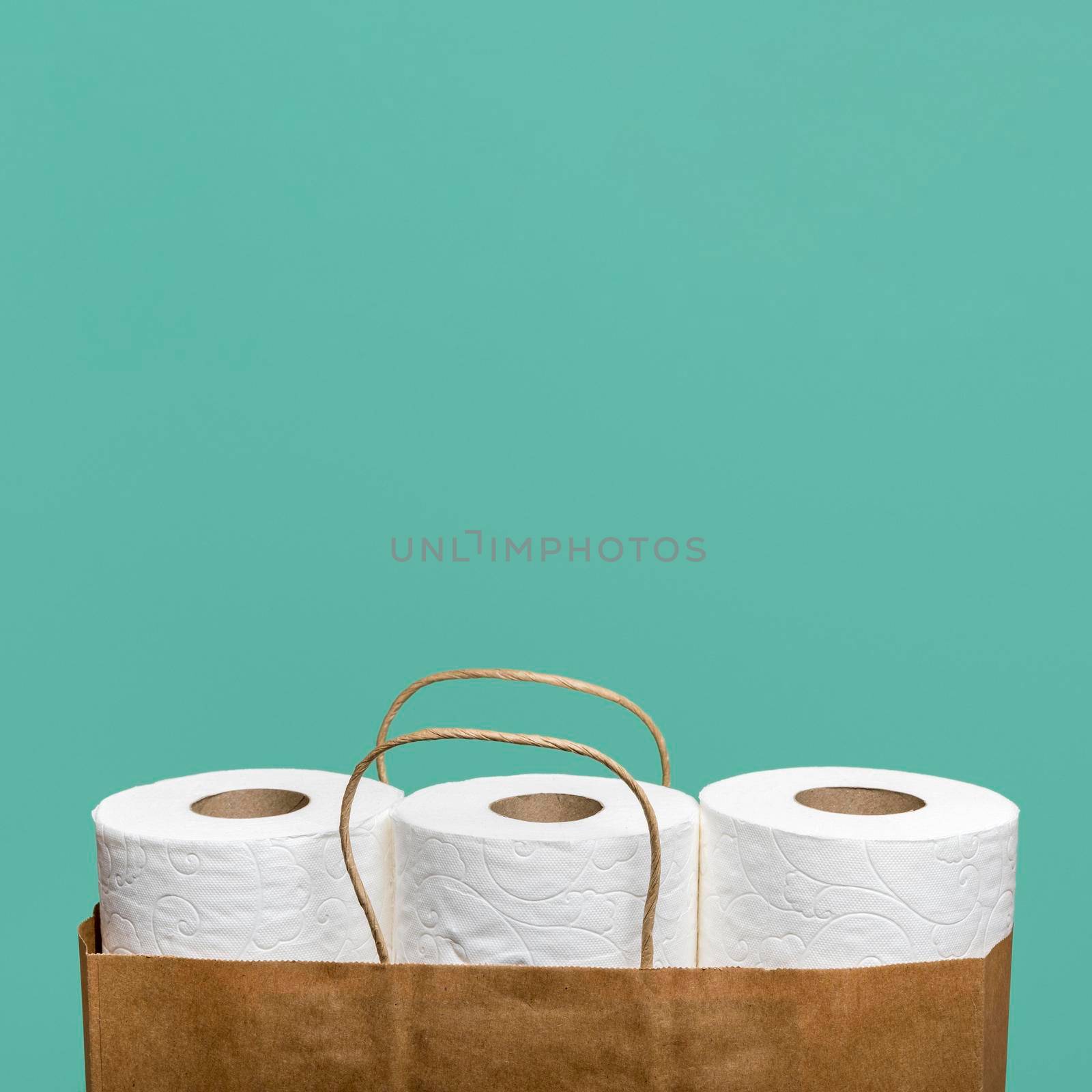 front view three toilet paper rolls paper bag. High resolution photo