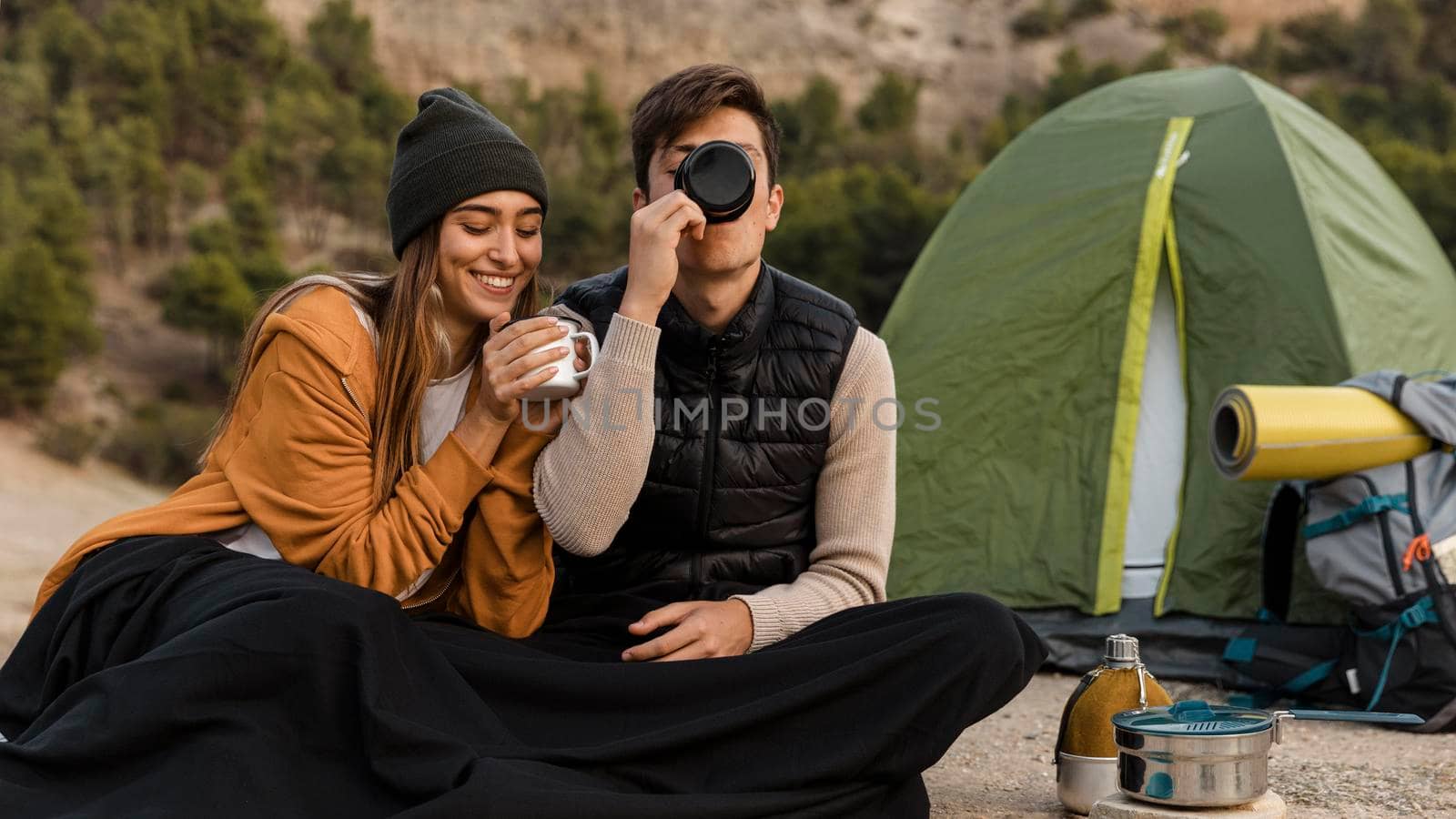 couple camping drinking tea together. High resolution photo