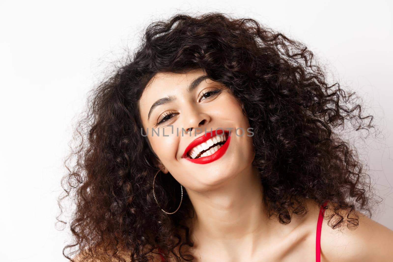 Close-up portrait of happy beautiful woman with curly hair and red lip, smiling white teeth, express happiness and joy.