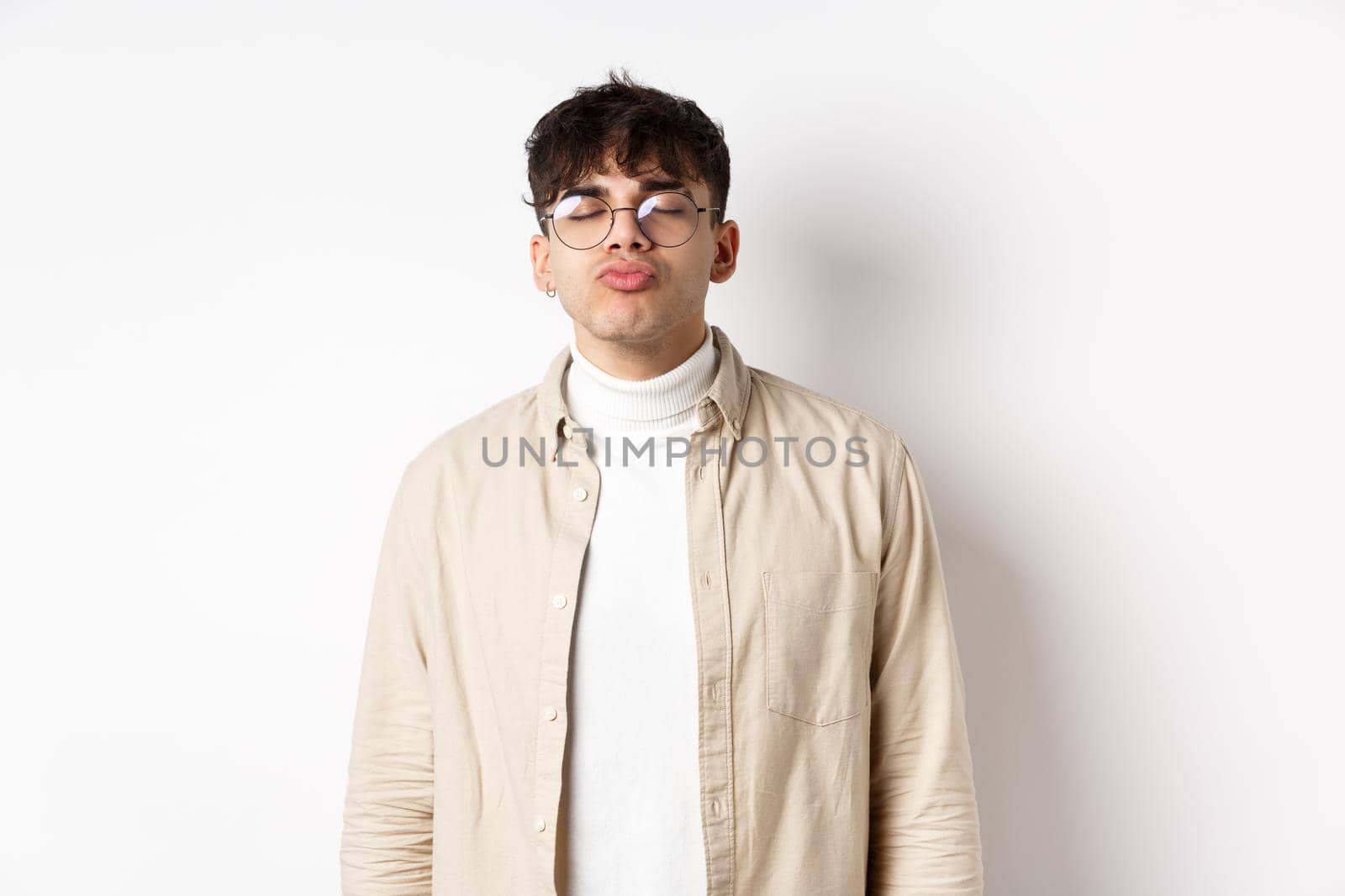 Cute boyfriend in glasses waiting for kiss, having romantic date on Valetines day, white background. Concept of relationship and romance.