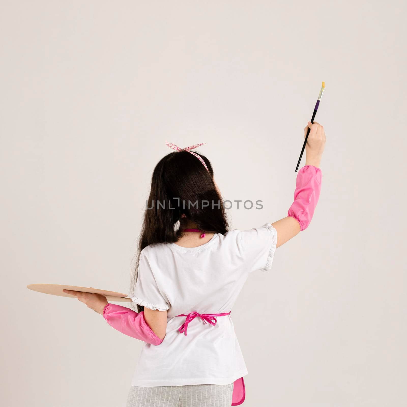 young girl painting back view. High resolution photo