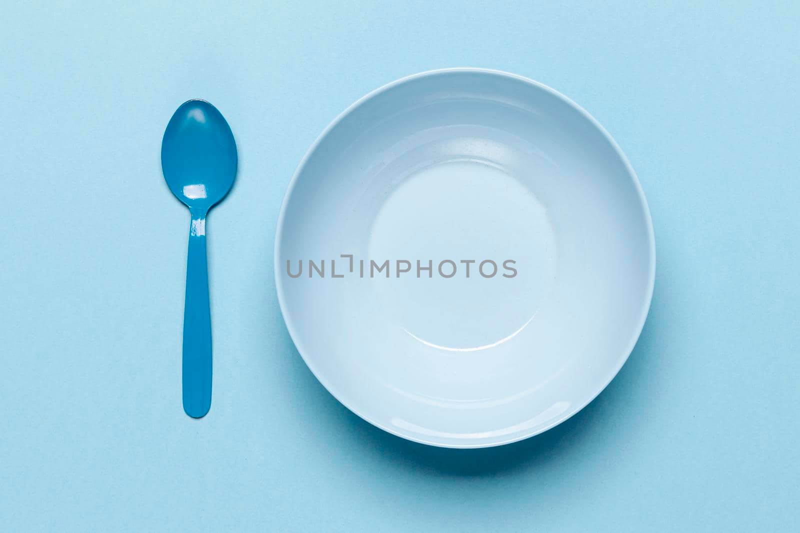 top view empty blue bowl spoon. High resolution photo