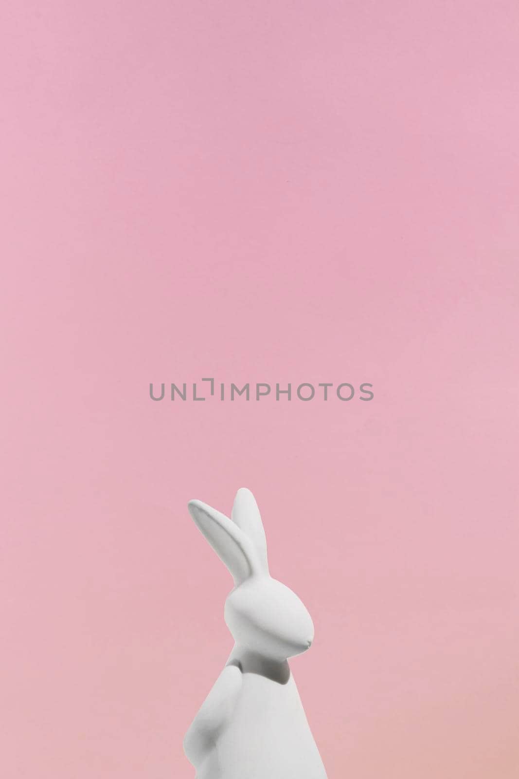 white rabbit figurine pink background. High quality photo by Zahard