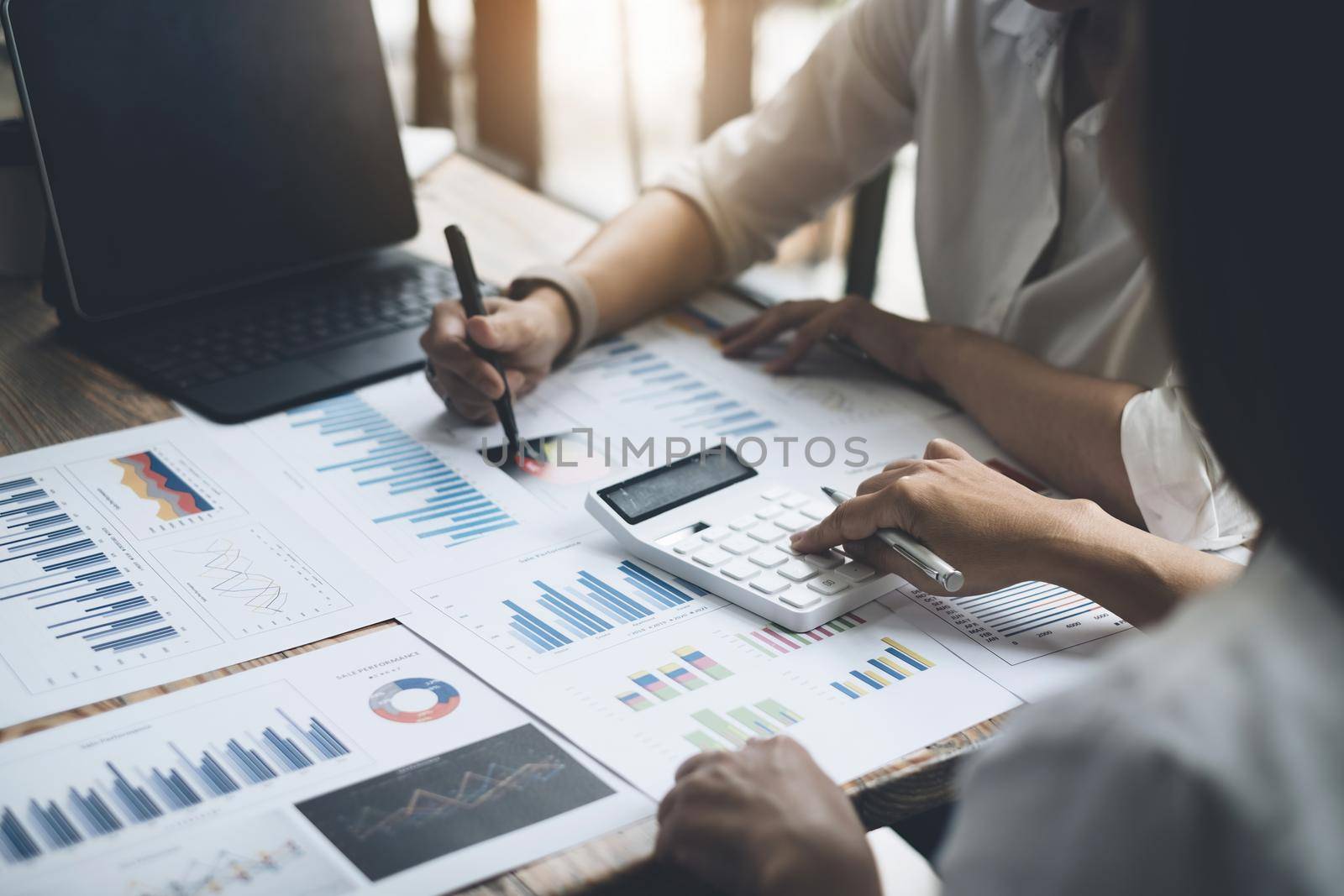 Asian Business woman accountant or banker and partners use calculator to audit and analysis finance planning sales to meet targets