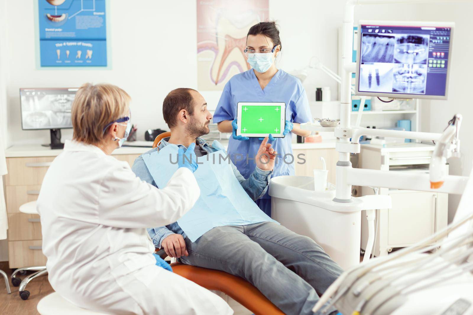 Medical nurse holding mock up green screen chroma key tablet by DCStudio