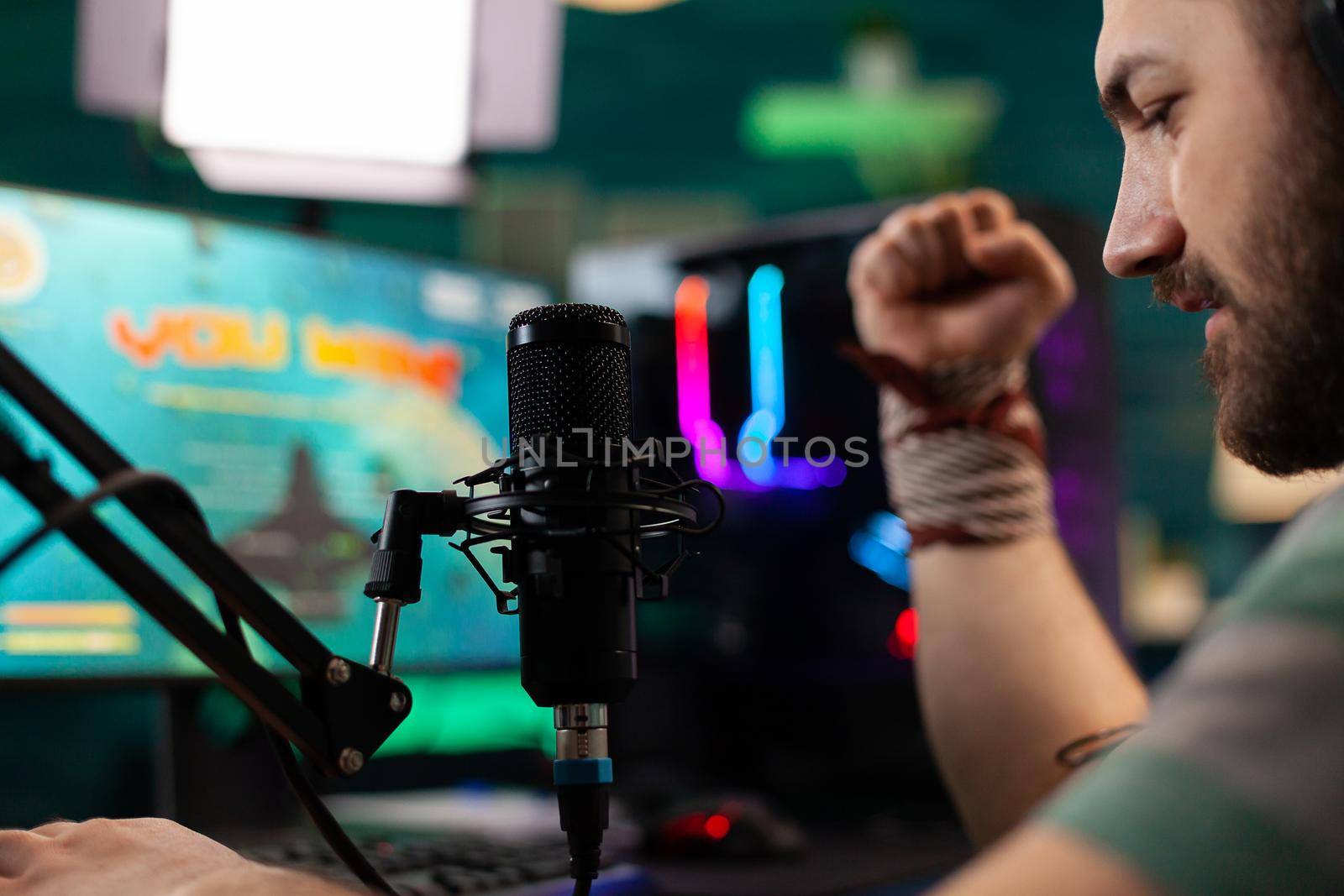 Close up of streamer winning shooter videogames for live competition in home studio. Online streaming cyber performing during gaming tournament using powerful PC with RGB.