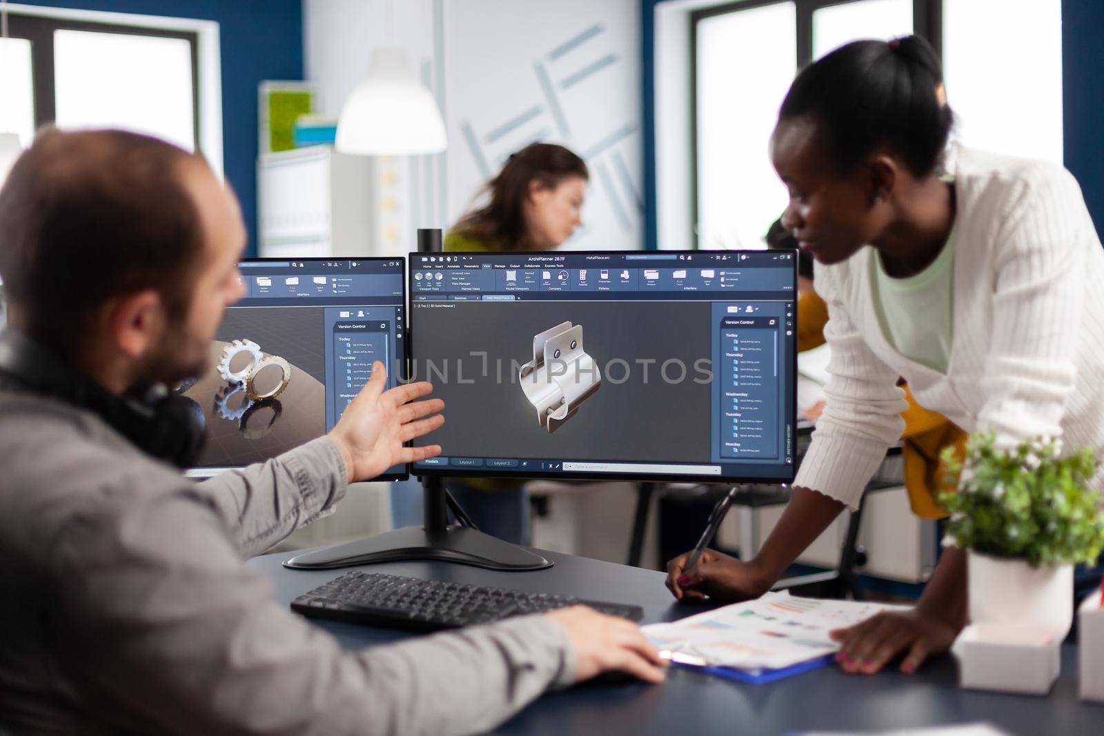 Diverse team of engineer architects working on modern cad program developing construction metalic components. Industrial designer studying prototype idea on pc showing digital software with gears