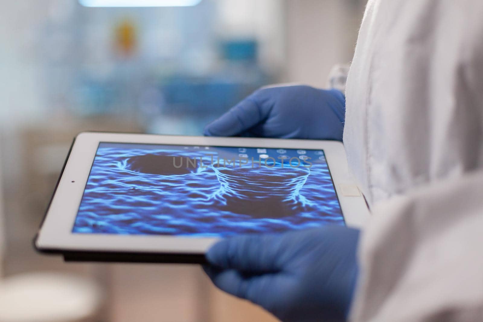 Close up of chemist doctor working on tablet with DNA scan image analysing treatment results. Scientist examining virus evolution using high tech technology researching vaccine development against covid19.