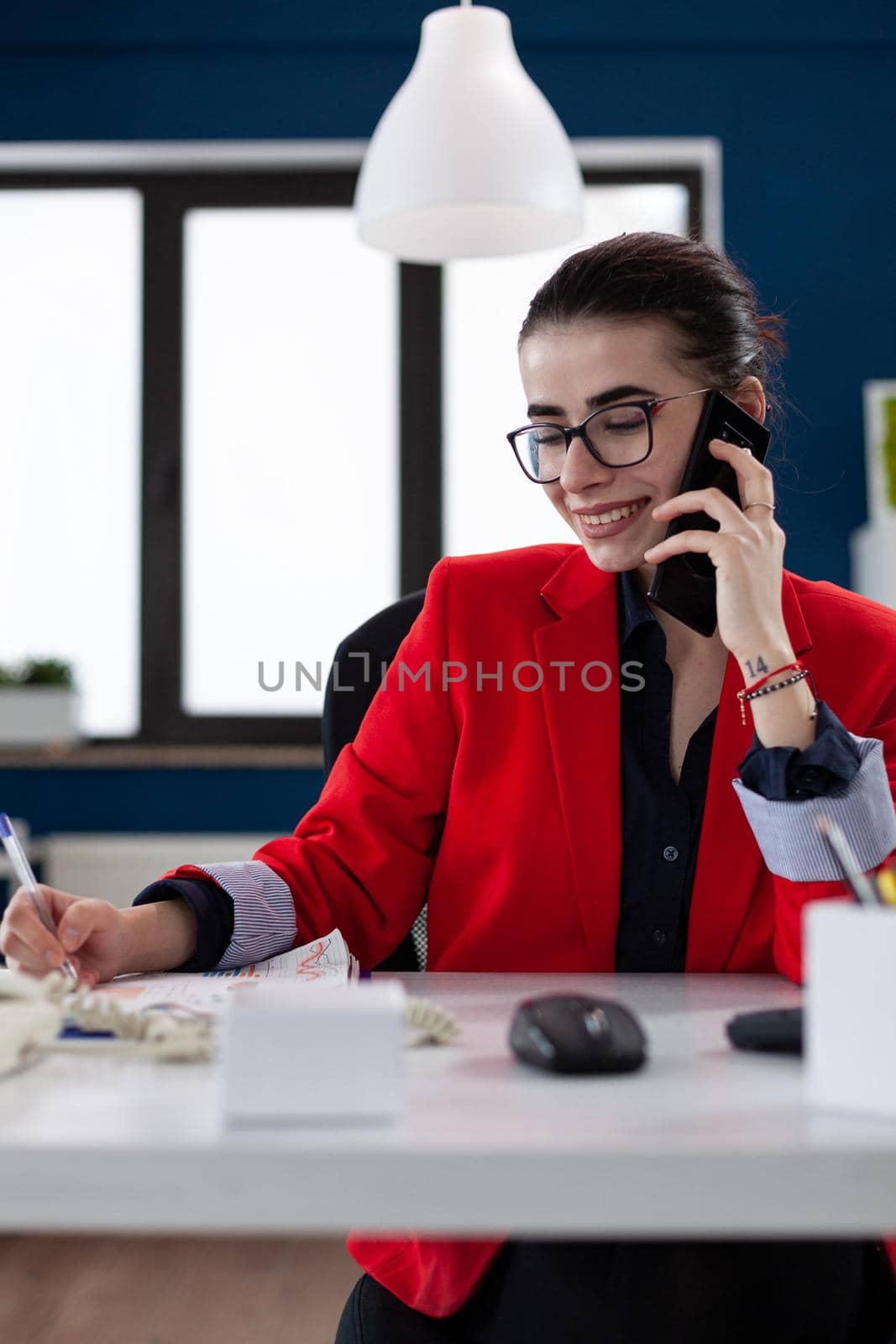 Financial adviser discussing with client during phone call conversation, looking at official documents. Company manager answering executive questions during mobile call sitting at desk in workplace .