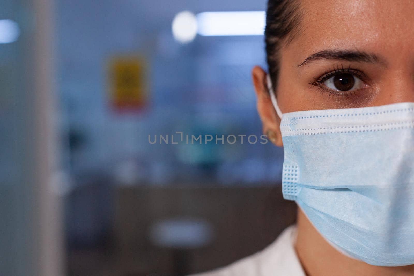 Close up of professional woman working in test laboratory for scientific experiment analysis. Biochemistry worker wearing face mask in medical environment to find innovation treatment