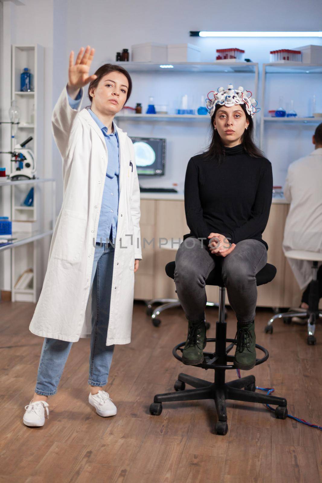 Brain scientis and patient in laboratory looking at virtual display using high tech medical science. Scientists working with healthcare simulator. Neurology physician analysing brain scan.