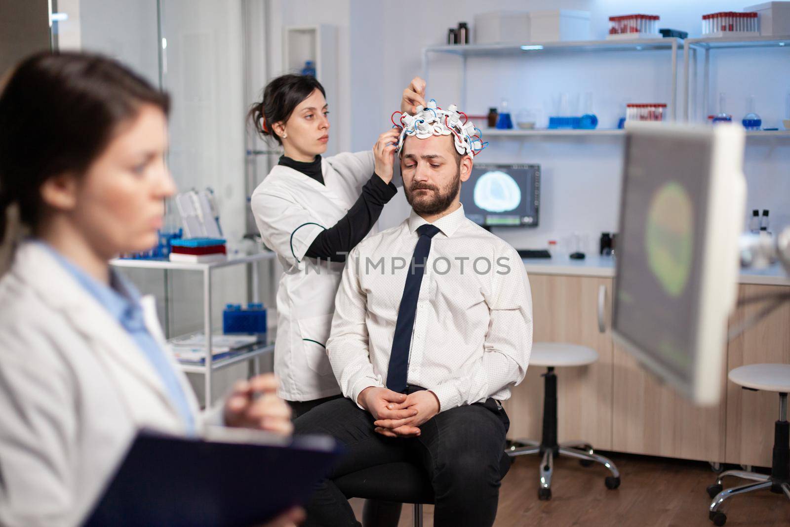 Man patient visiting professional medical researcher in neurology medicine testing brain functions with eeg headset. Doctor monitoring nervous system, descovering diagnosis of disease.