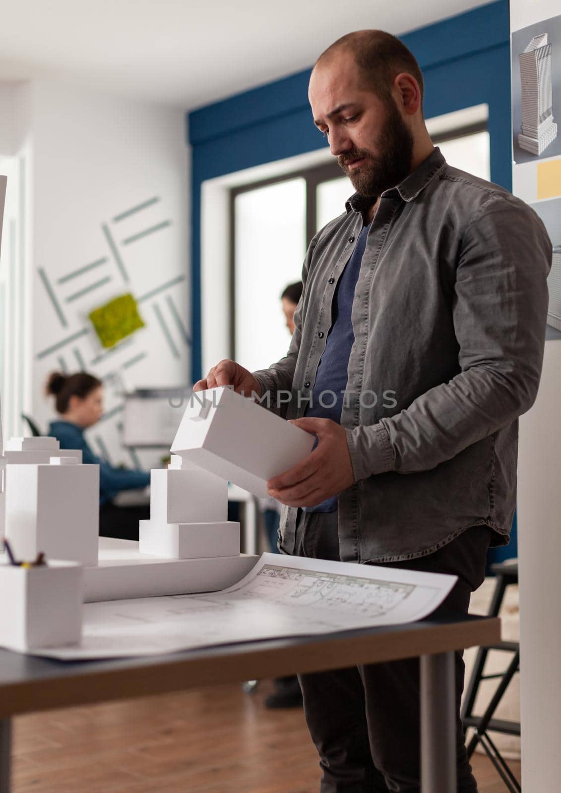 Architecture expert person looking at maquette building model design plan. Engineer manager working on modern sketch layout in profesional environment for urban industry development