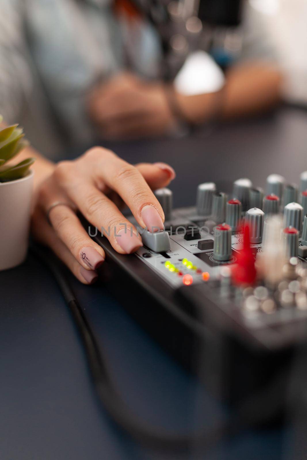 Close up of checking sound using mixer during online podcast. Social media influencer making professional content with modern equipment and digital web internet streaming station