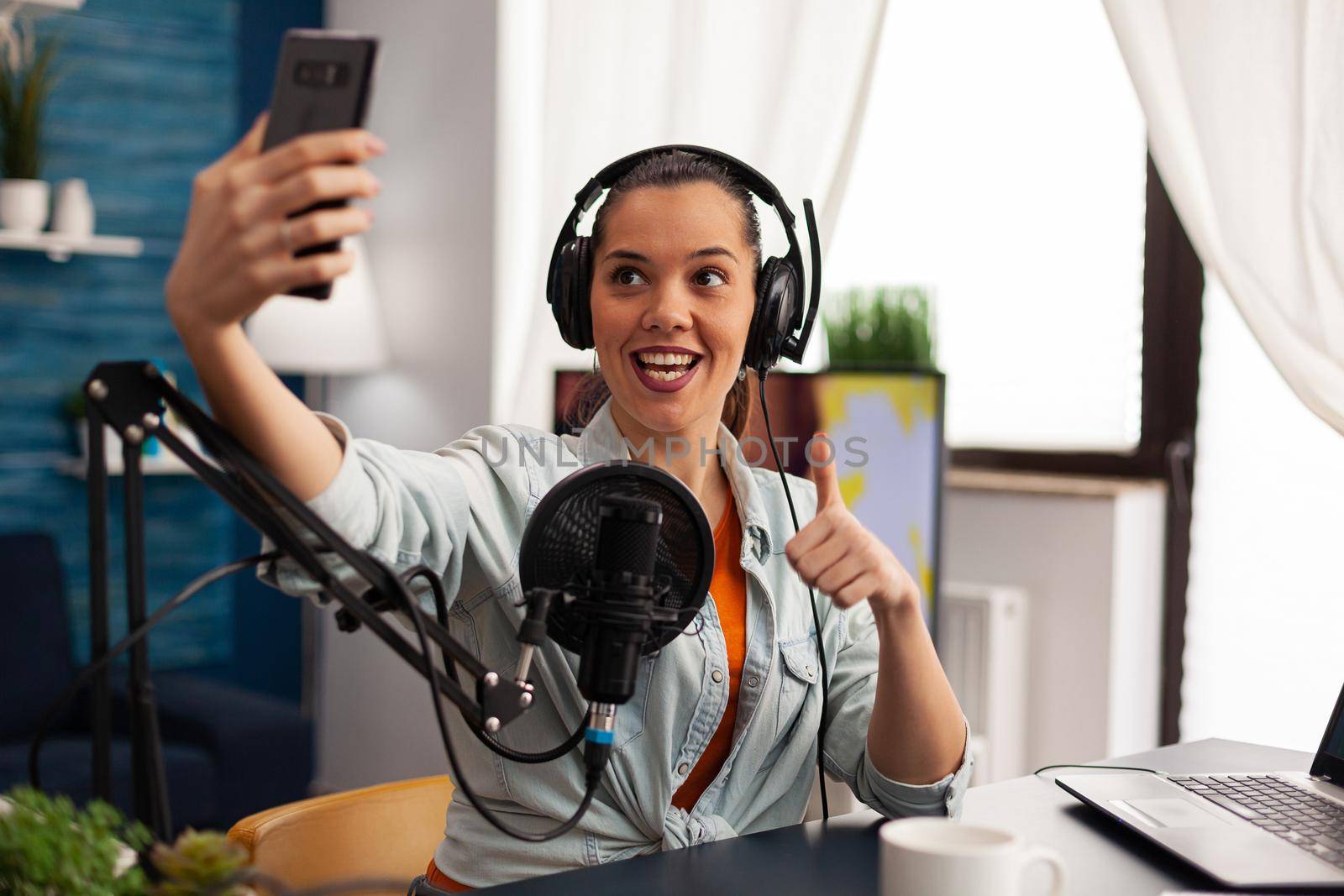 Portrait of blogger, vlogger woman taking pictures of herself on the smartphone by DCStudio