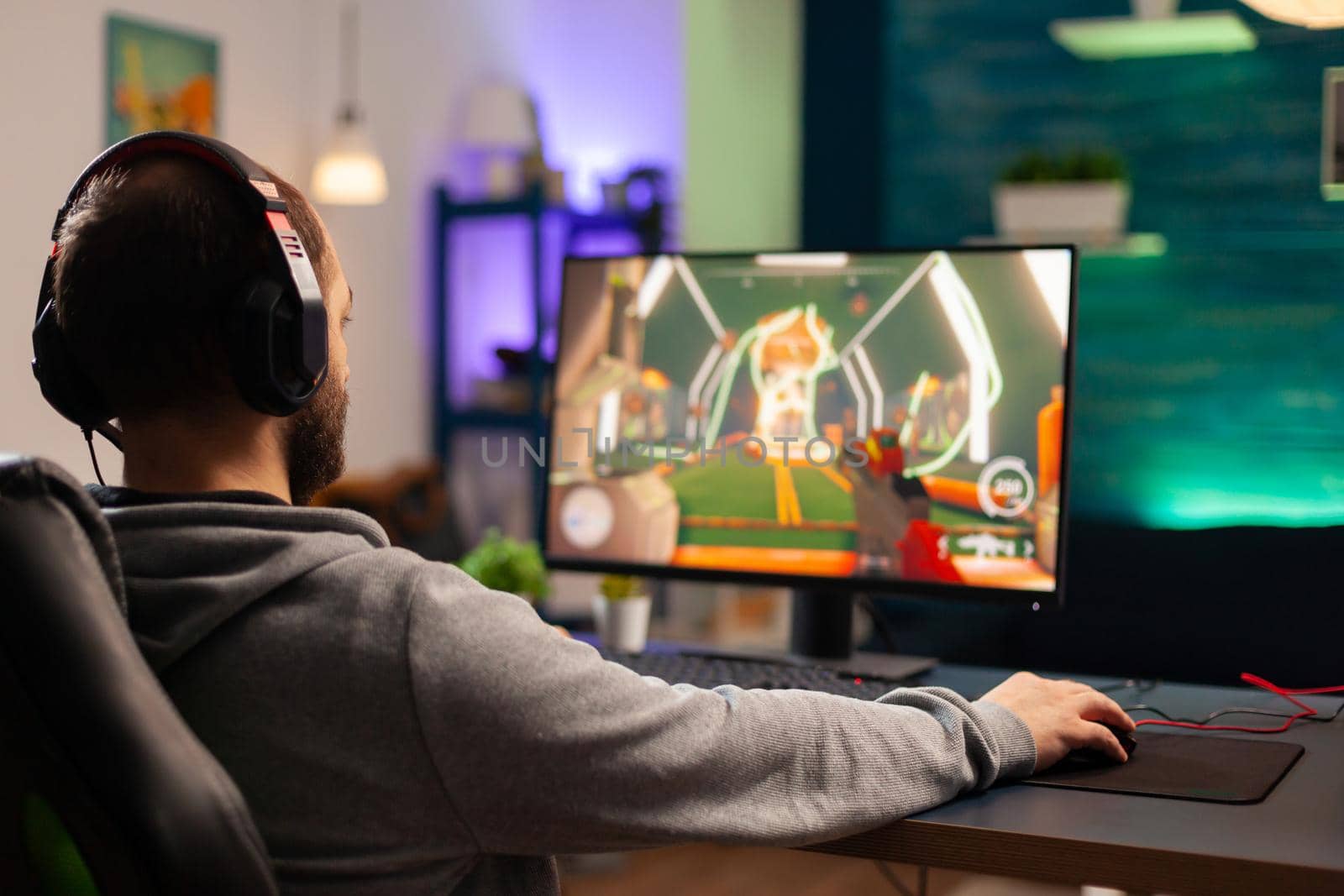 Professional player with headset playing videogame by DCStudio