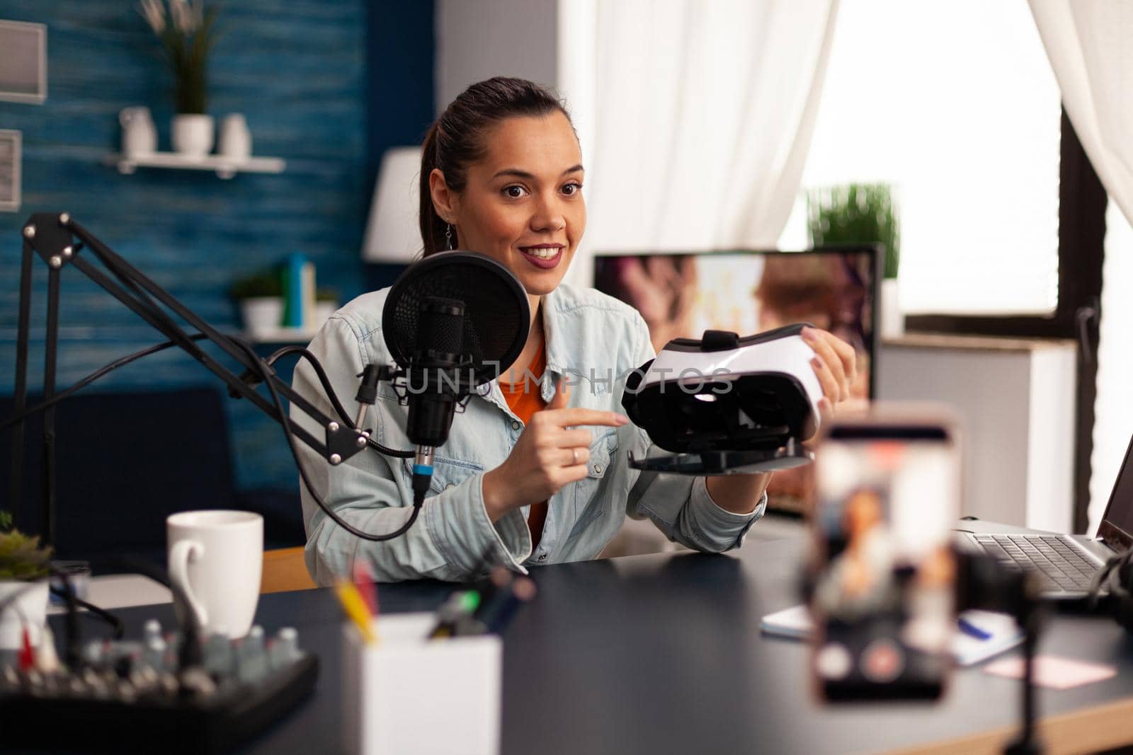 New media influencer smiling at camera while recording vr headphones review for followers by DCStudio