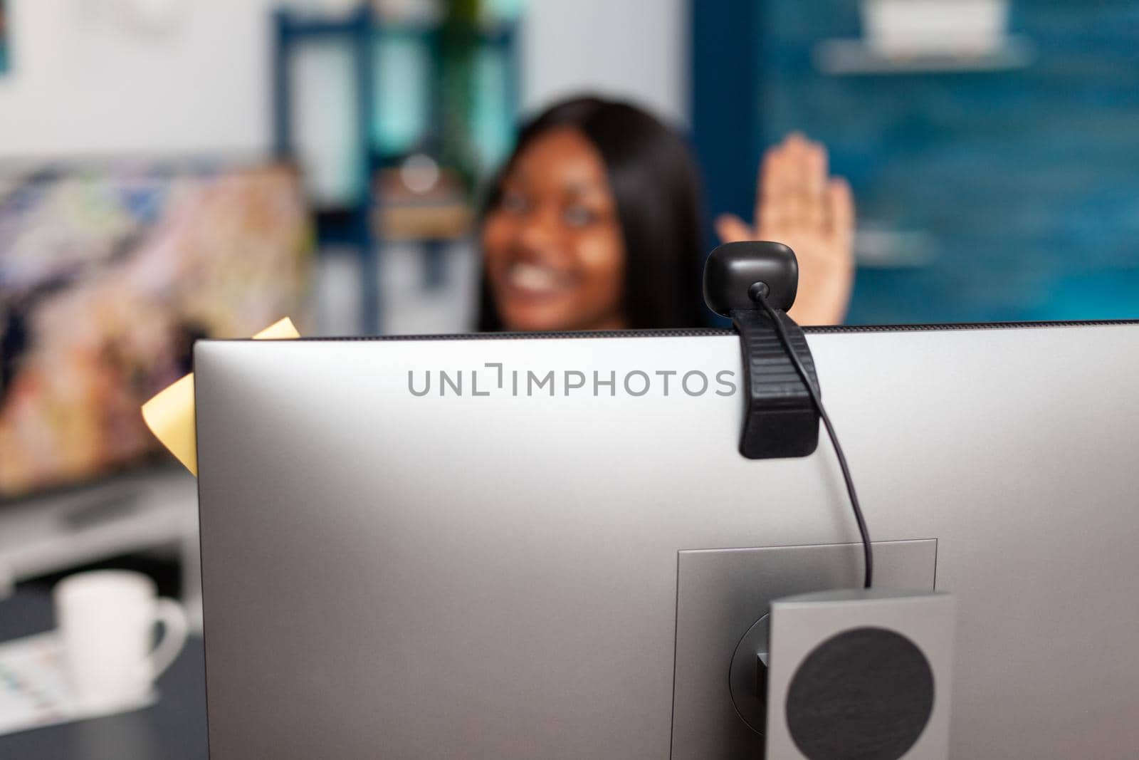 Student with dark skin greeting university teacher listening math lesson during online videocall meeting conference working remote from home. Selective focus on computer webcam