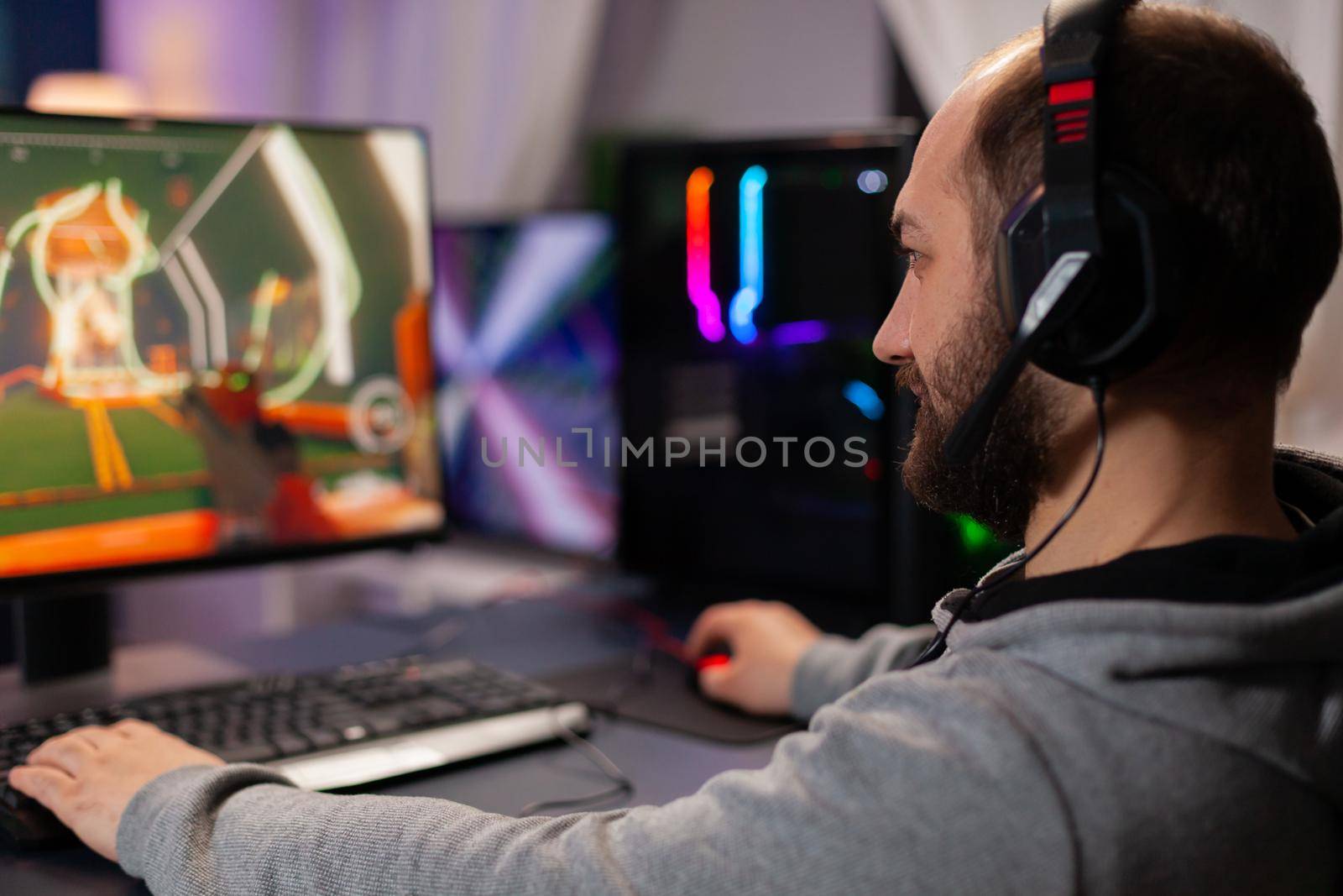 Digital player wearing headphones playing videogame with modern graphics for shooter game championship. Online streaming cyber performing during gaming tournament using powerful PC with RGB