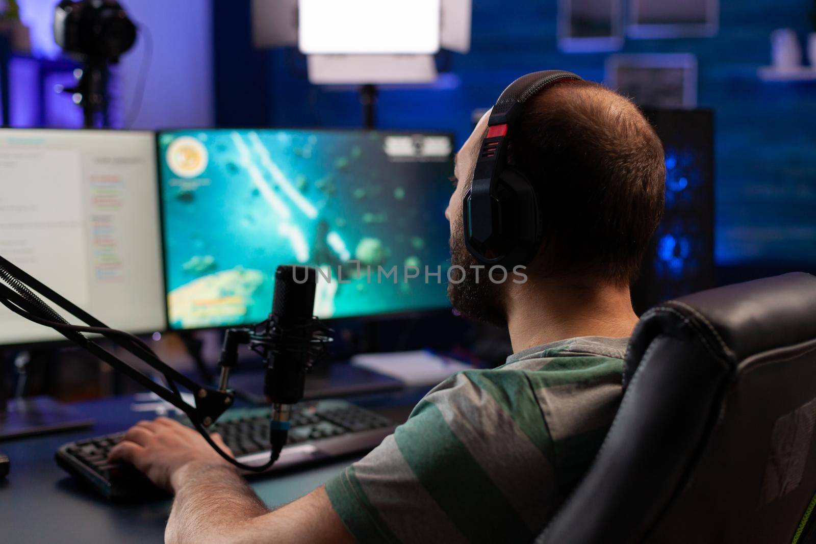 Concentrated gamer playing shooter game by DCStudio