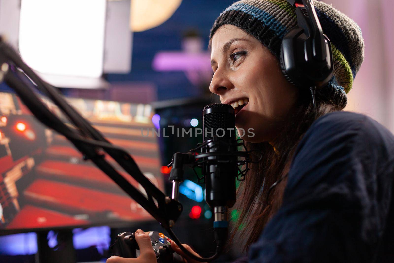 Close up of streamer woman talking into professional microphone in home studio. Online streaming cyber performing gaming tournament using technology network wireless