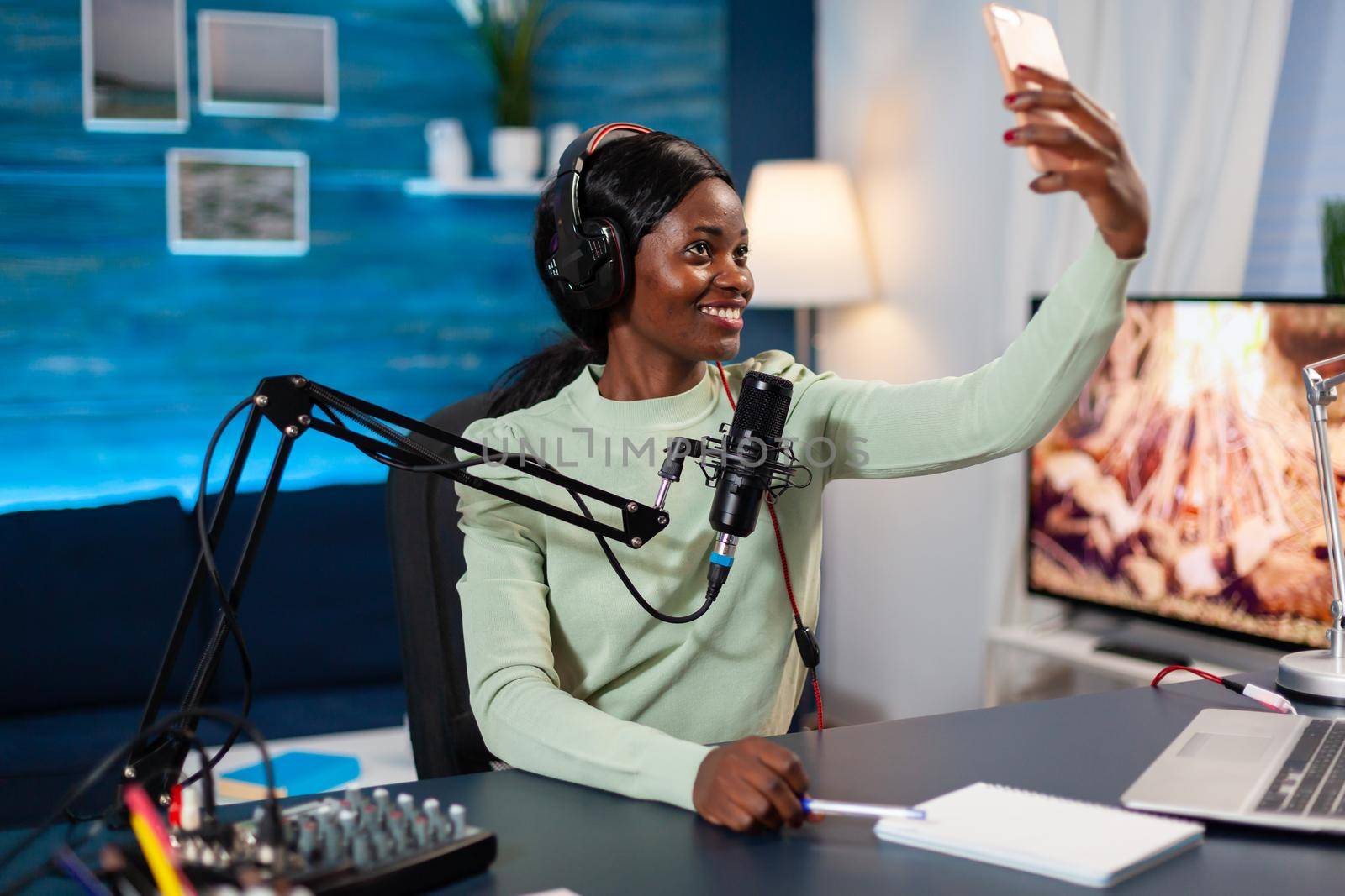 African influencer recording podcast and taking selfie by DCStudio