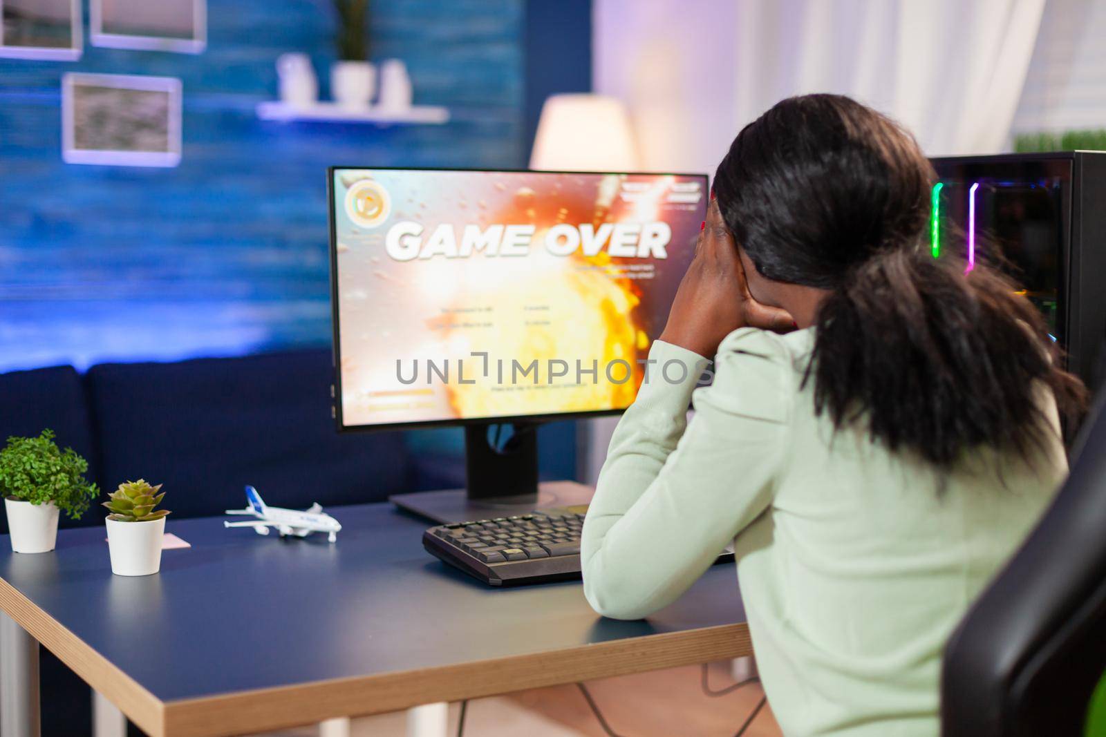 Disappointed sad african woman after losing online game competition Angry professional gamer gaming over during an space shooter online video game.