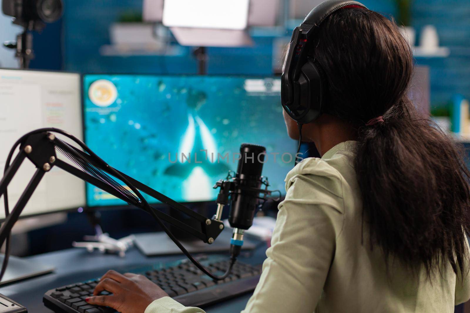 African esport player talking with teammates during live stream space shooter competition Streaming viral video games for fun using headphones and keyboard for online championship.