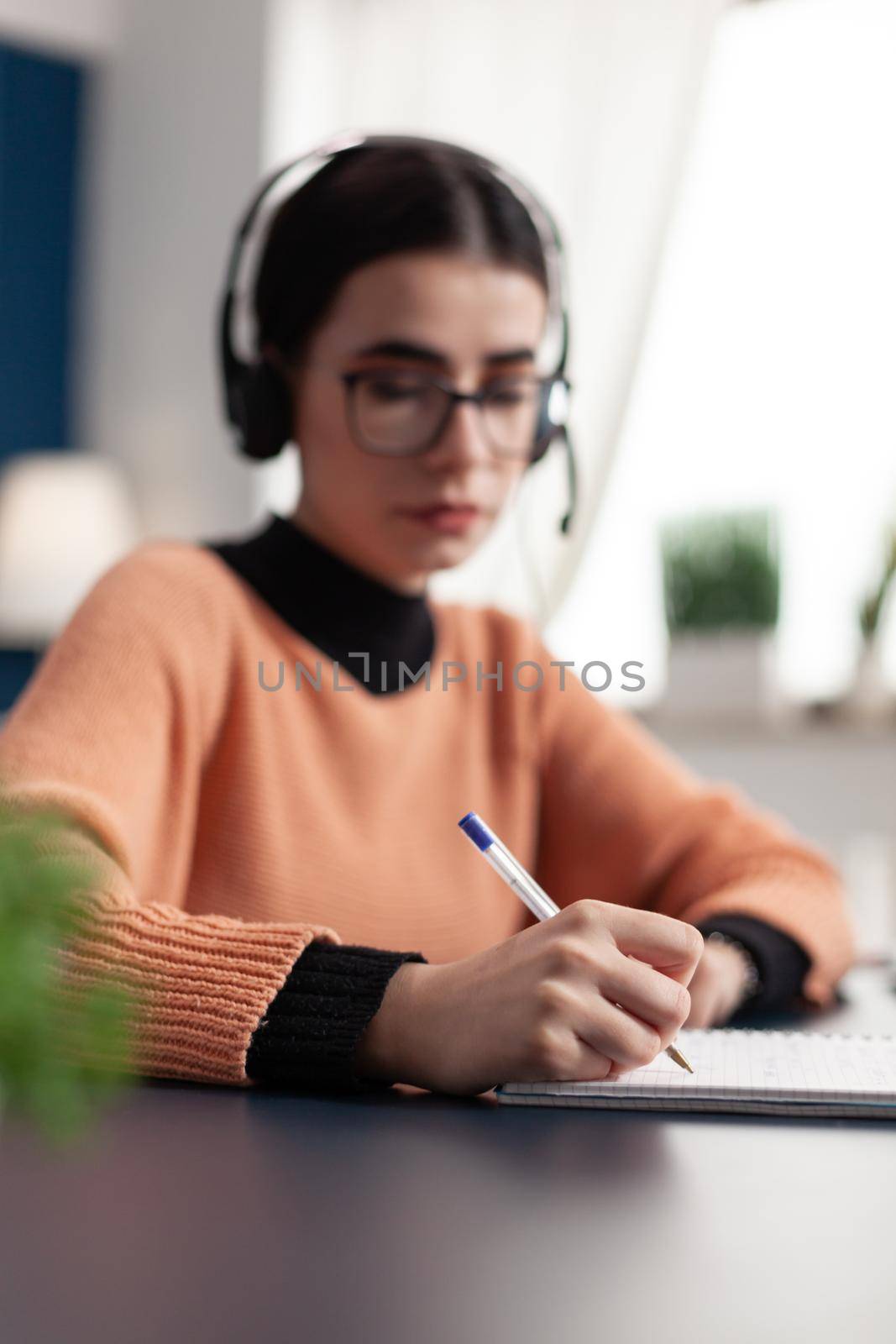 Young college student writing communication information on notebook by DCStudio