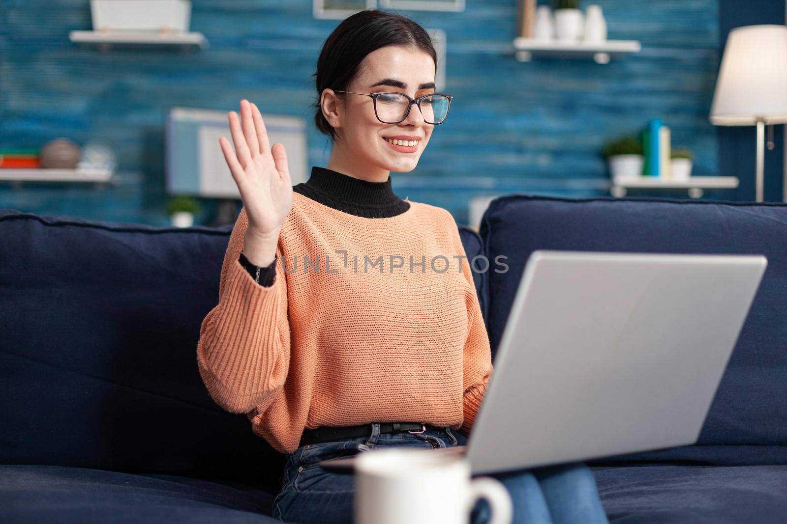 Young woman greeting her teacher during virtual videocall meeting by DCStudio