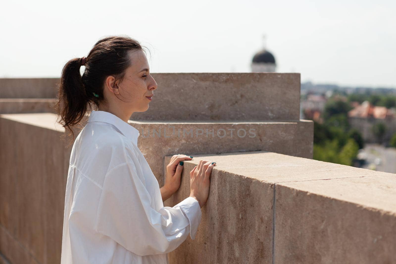 Caucasian female enjoying looking at metropolitan city from panoramic terrace by DCStudio