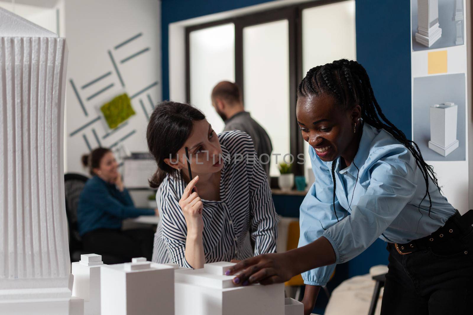 Women of architect profession standing at desk office by DCStudio