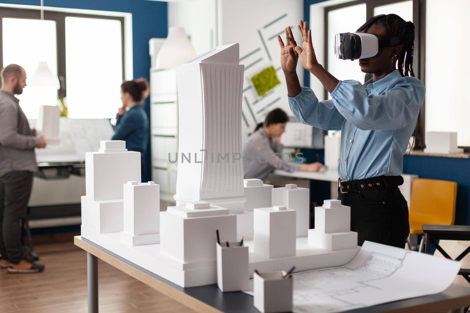 African american woman using vr glasses at work by DCStudio
