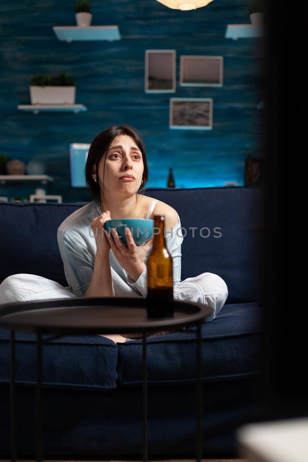 Depressed woman watching drama movie on tv crying having emotional expression by DCStudio