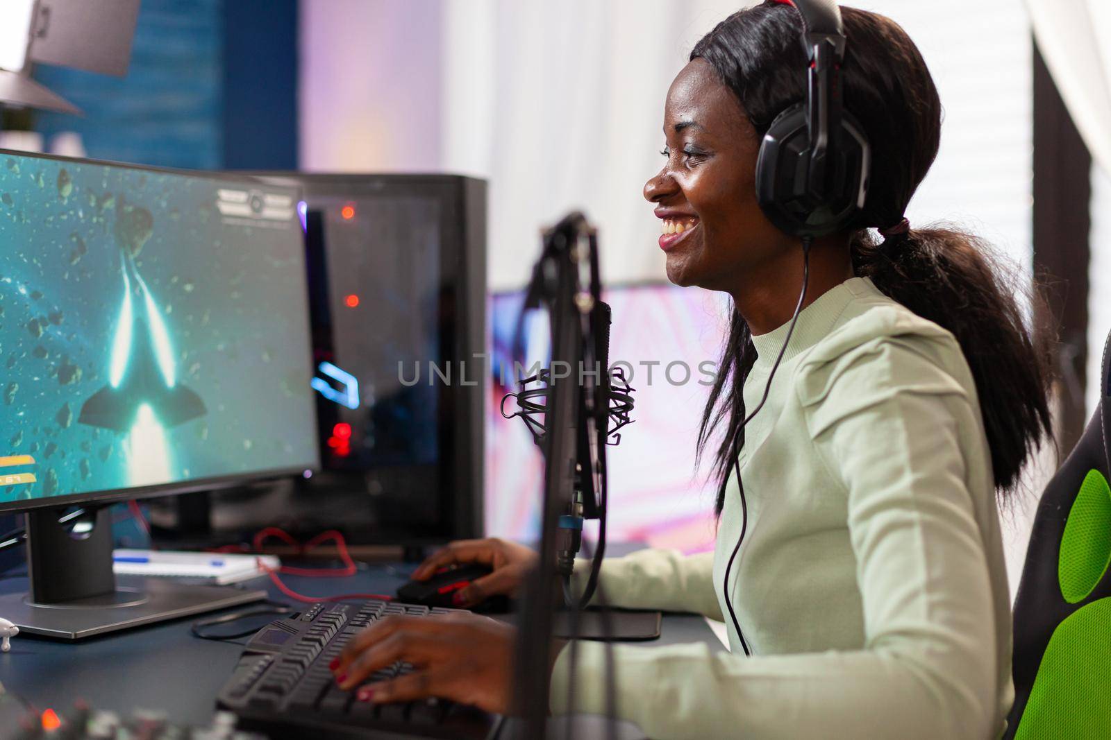 Competitive e-sport professional gamer player talking into microphone at night. Streaming viral video games for fun using headphones and keyboard for online championship.