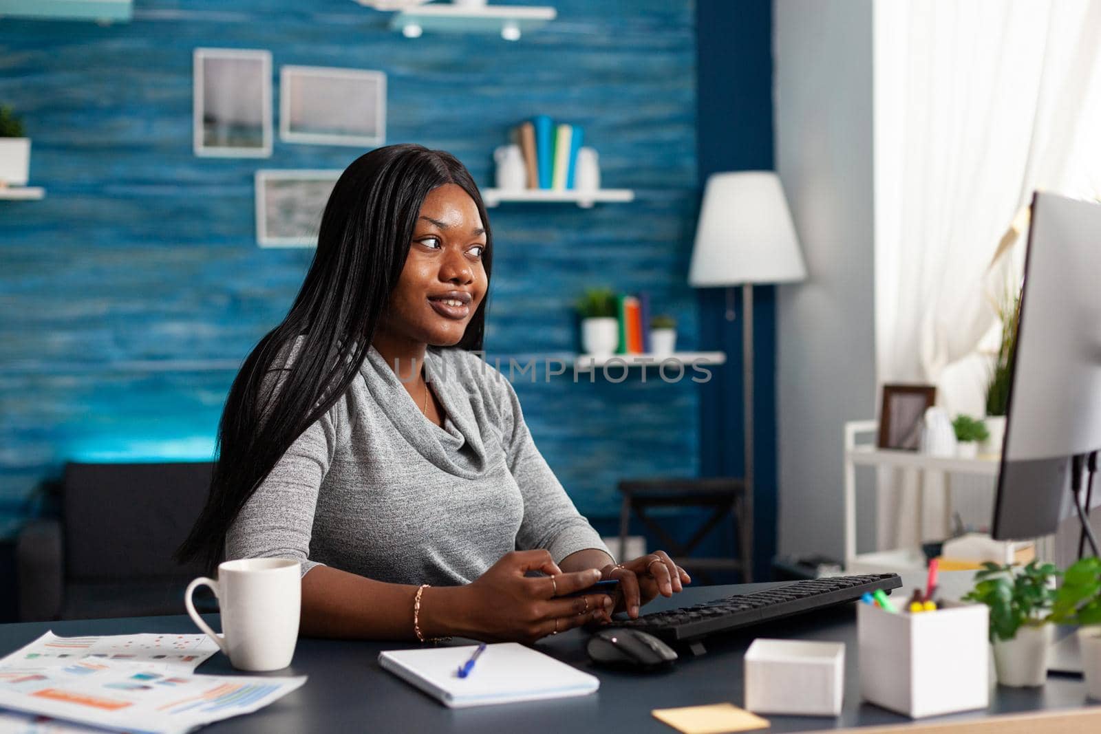 African student holding credit card in hands doing online transcation searching shop store by DCStudio