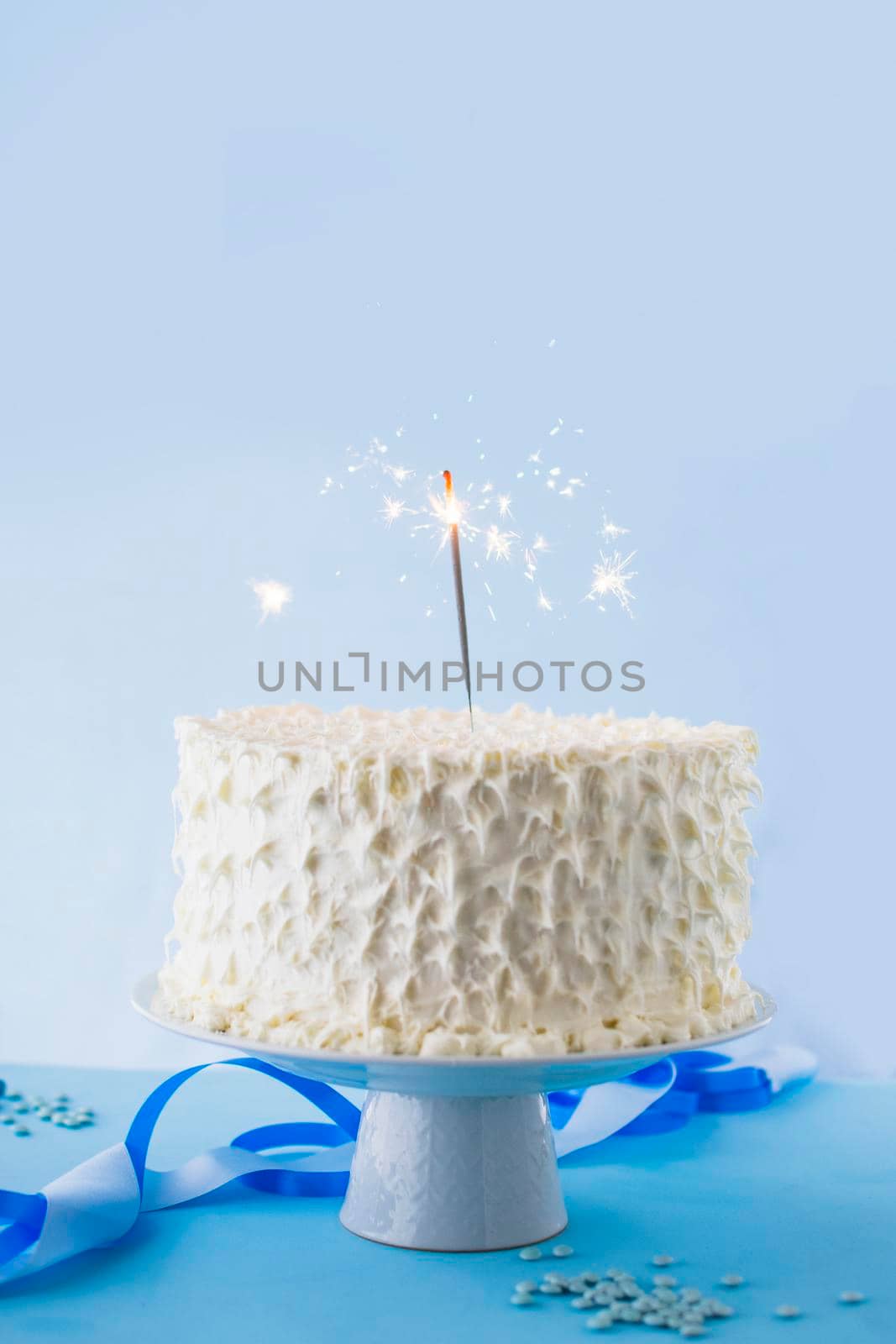 white birthday cake with burning sparkler. High quality photo by Zahard