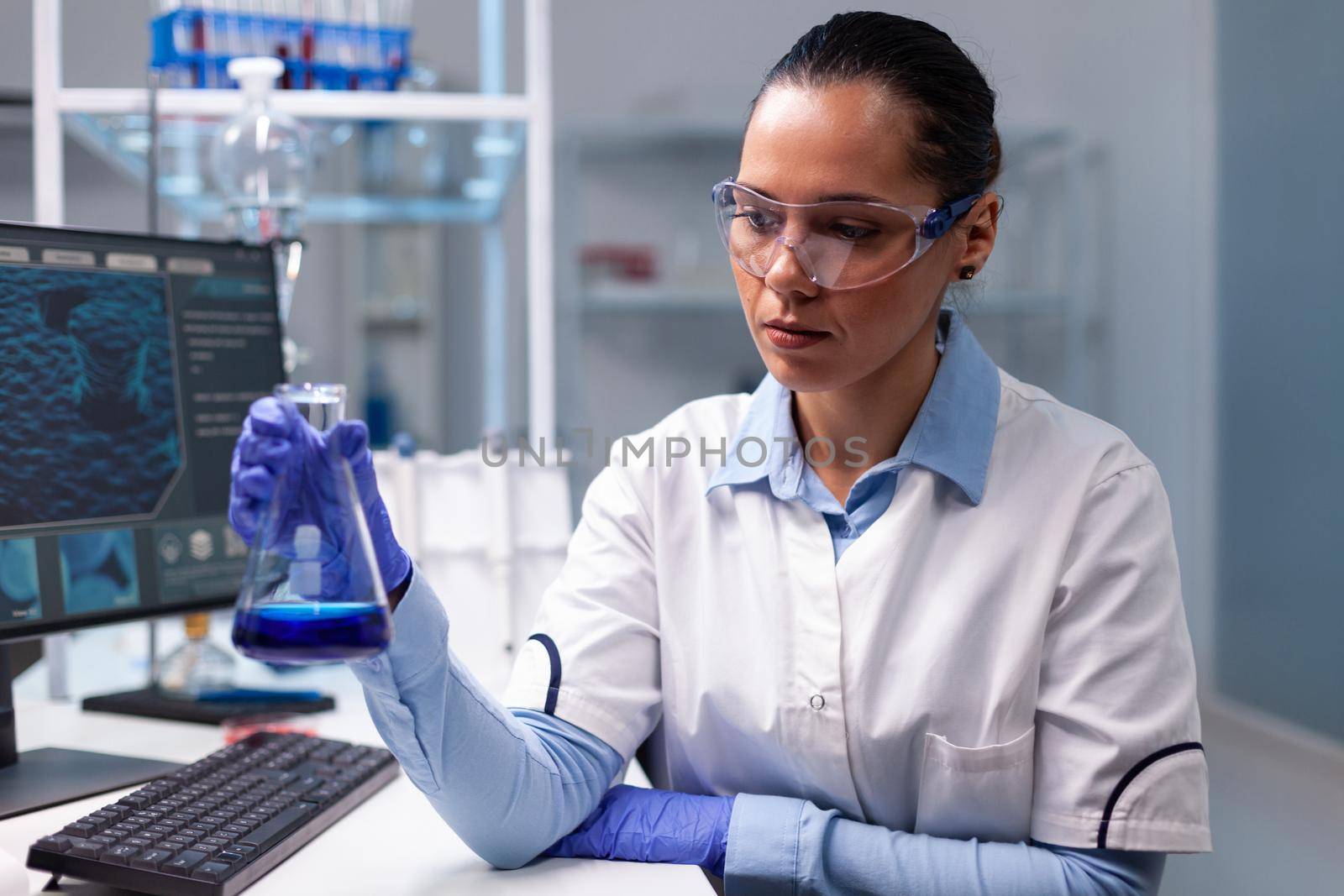 Chemist woman analyzing liquid solution holding medical glass flask researching disease dna expertise results. Scientist doctor developing biochemistry diagnostic working in hospital laboratory