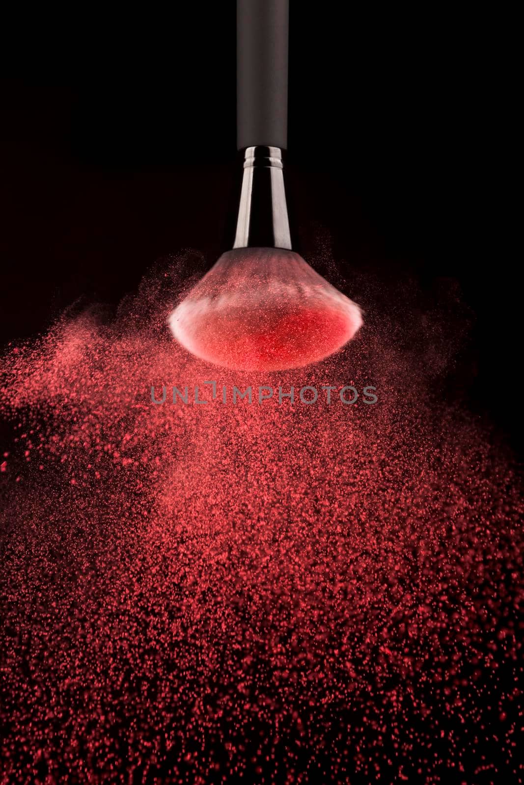 upside down makeup brush red powder splash. High resolution photo
