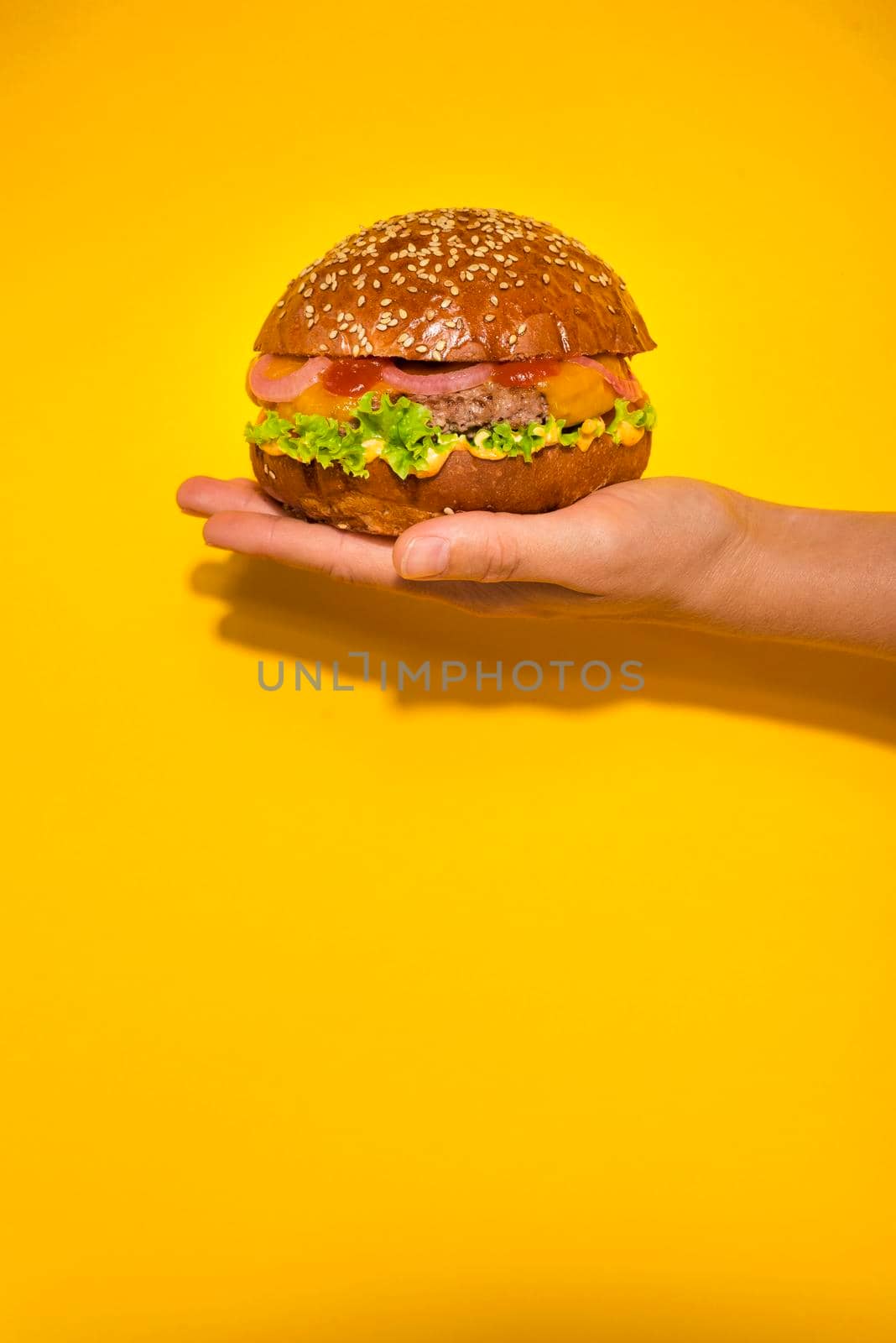 hand holding classic beef burger with lettuce. High quality photo by Zahard
