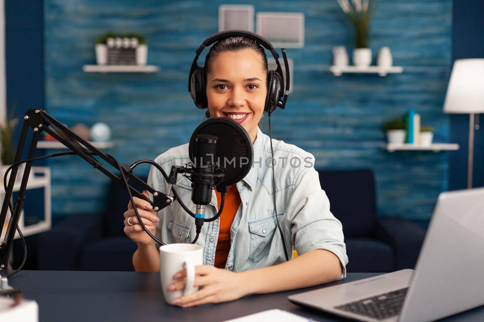 Influencer wearing headphones recording new podcast series at home studio for youtube channel. On-air online production internet broadcast show host streaming live social media content