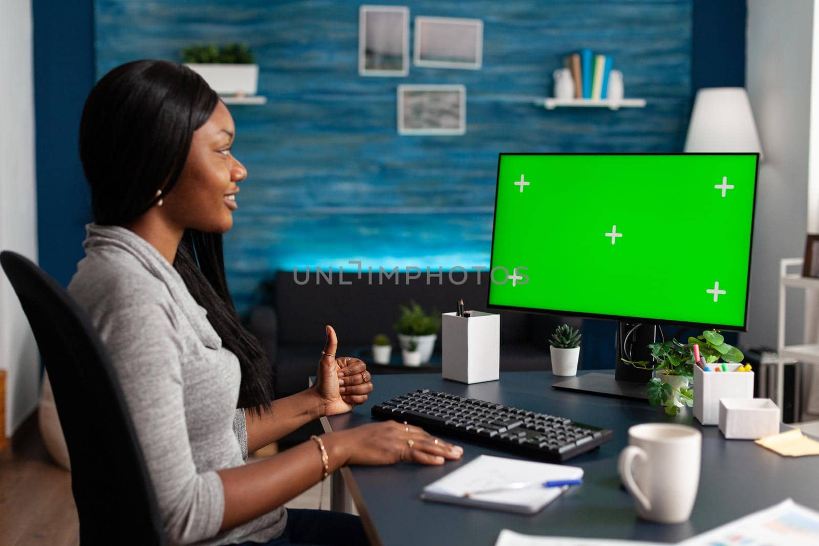 African american student sitting at desk working remote from home during high school online webinar by DCStudio