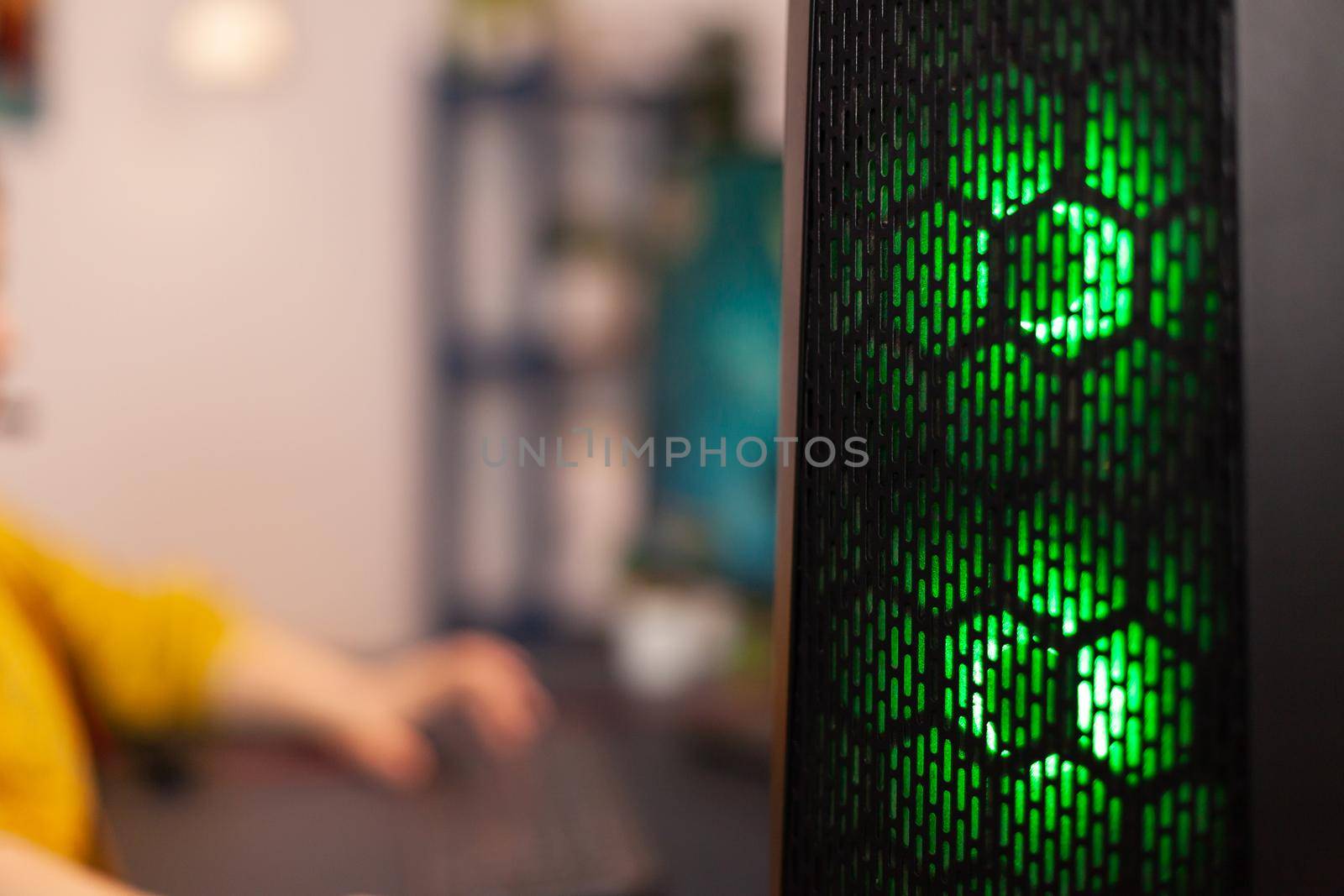 Room with powerful computer for online competition and streaming chair, home studio is equipped with professional gaming equipment. Cyber performing in stylish room playing online shooter game.