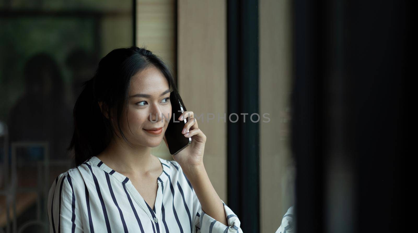 Close up Young Asian Woman Talking to Someone on her Mobile Phone by nateemee