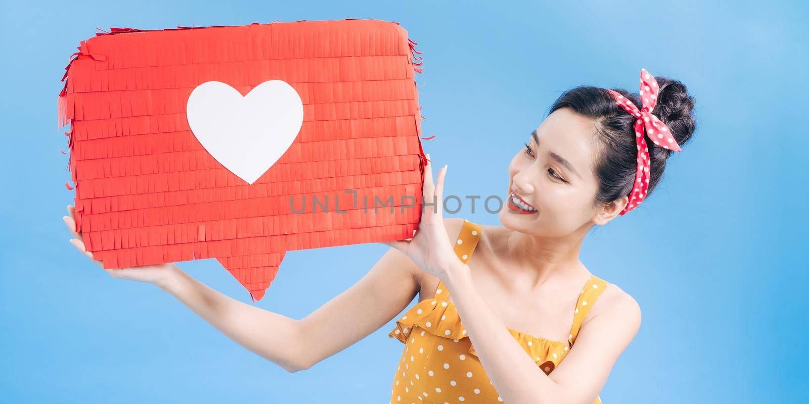 woman holding paper like sign isolated on blue