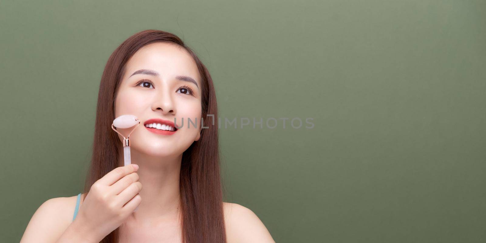 Woman using face roller For Face Massage by makidotvn