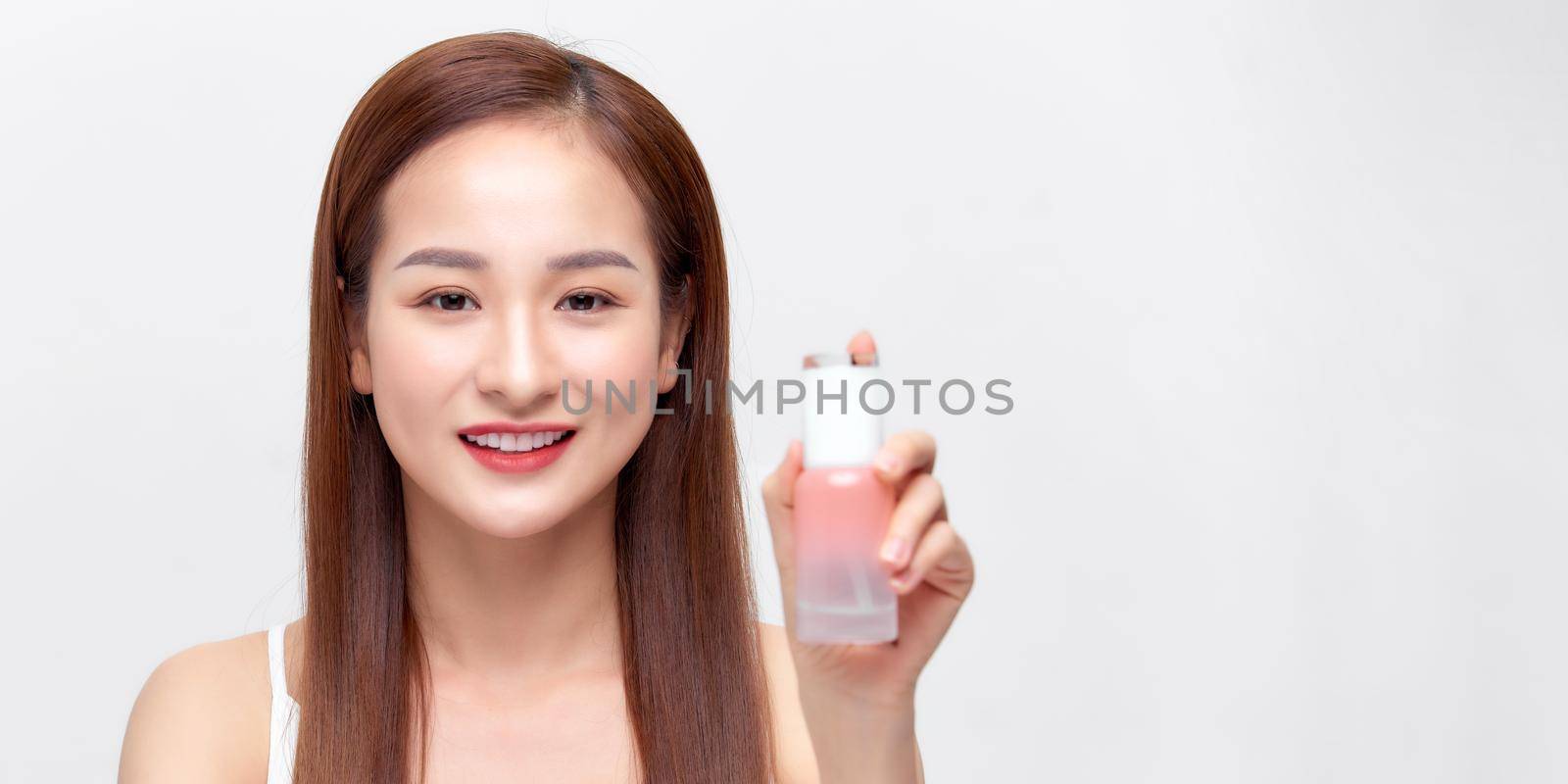 Closeup Healthy Young Female Holding Bottle Of Gel Near Beauty Face. by makidotvn